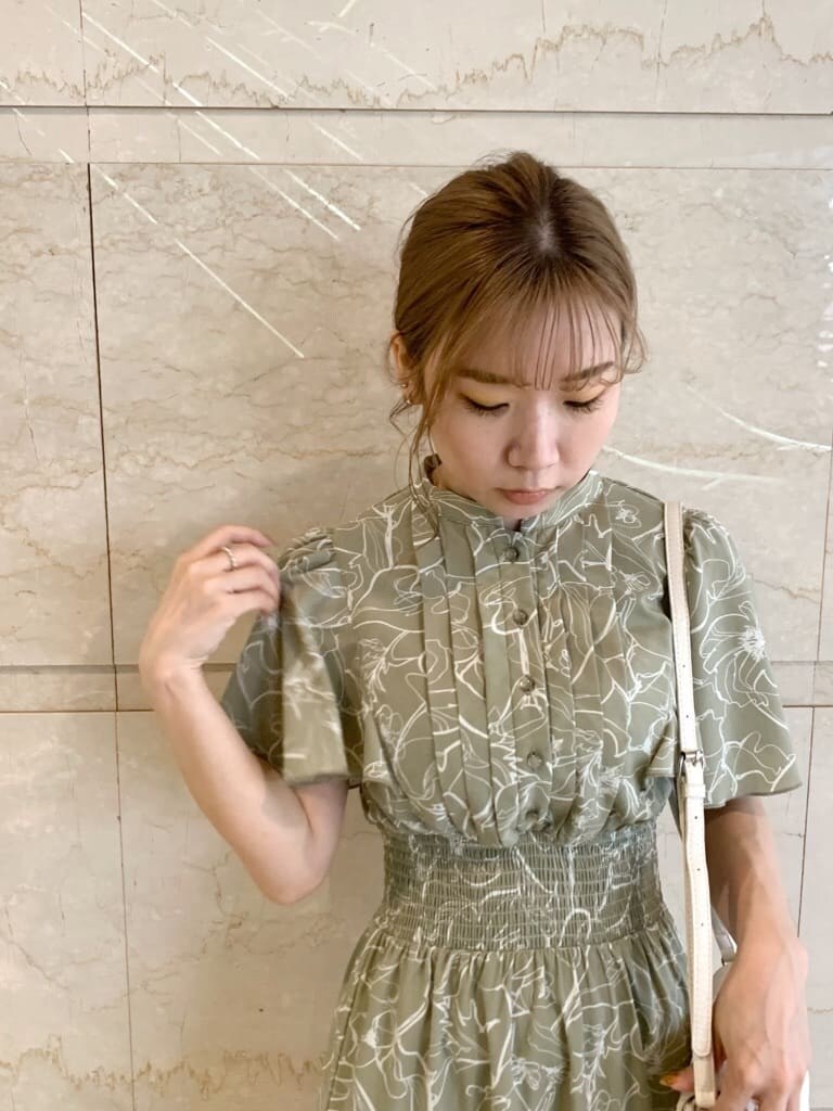 グリーン系のワンピース、ベージュ系のサンダル、ホワイト系のショルダーバッグを着用したレディースの春コーディネートの5枚目の写真