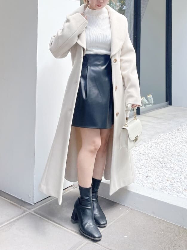 ホワイト系のその他アウター、ホワイト系のニット/セーター、ブラック系のスカートを着用したレディースの秋コーディネートの2枚目の写真