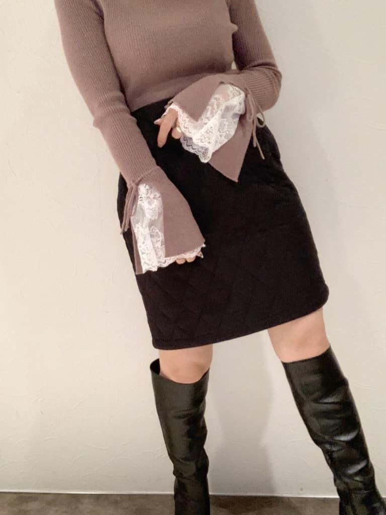 ブラック系のスカート、ブラック系のブーツ、ピンク系のニット/セーターを着用したレディースの秋コーディネートの6枚目の写真