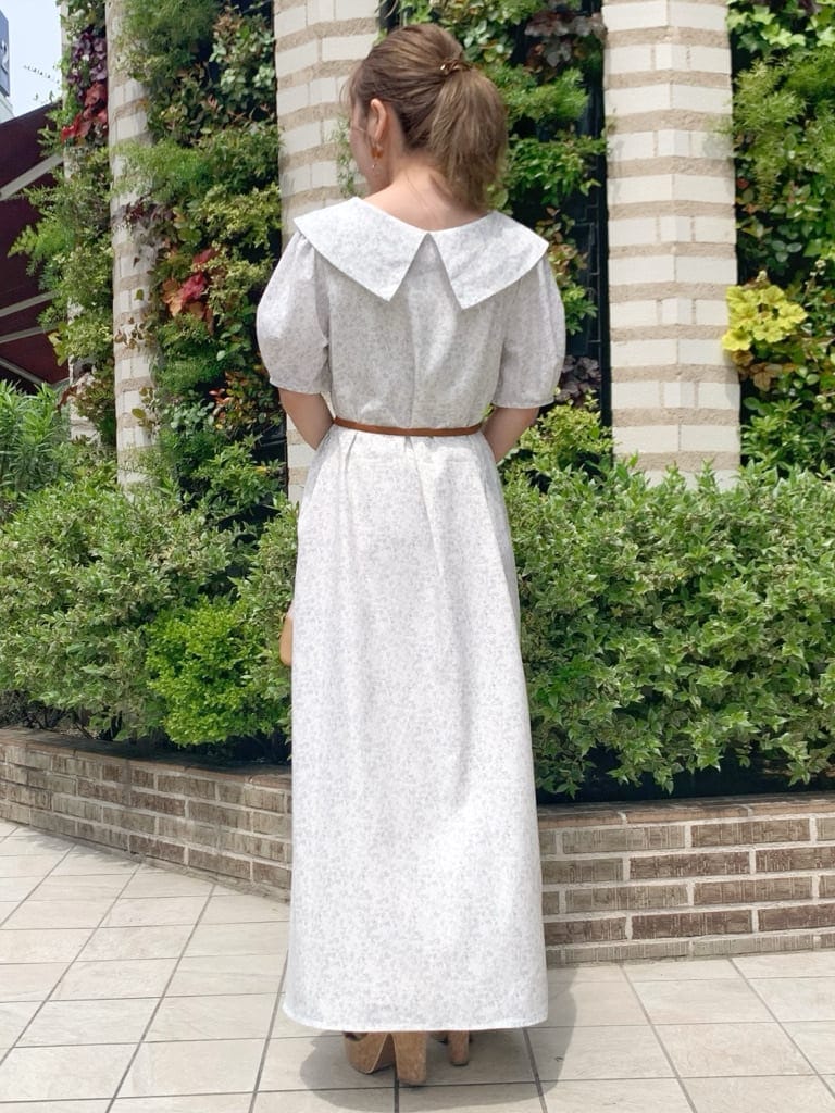 ベージュ系のハンドバッグ、ブラウン系のサンダル、ホワイト系のワンピースを着用したレディースの春コーディネートの4枚目の写真