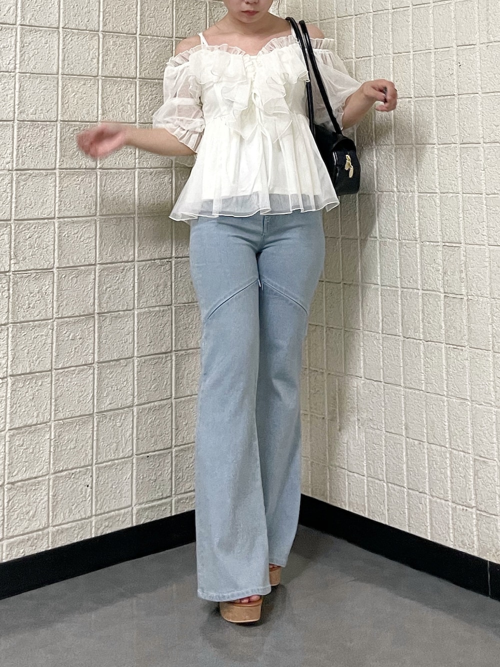 ホワイト系のシャツ/ブラウス、ブルー系のデニムパンツ、ブラウン系のサンダルを着用したレディースの春コーディネートの5枚目の写真