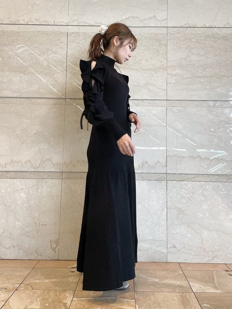 ベージュ系のブーツ、ブラック系のワンピース、ゴールド系のピアス（両耳用）を着用したレディースの秋コーディネートの4枚目の写真