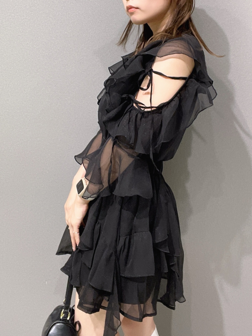 ブラック系のシャツ/ブラウス、ブラック系のスカート、ホワイト系のサンダルを着用したレディースの夏コーディネートの6枚目の写真