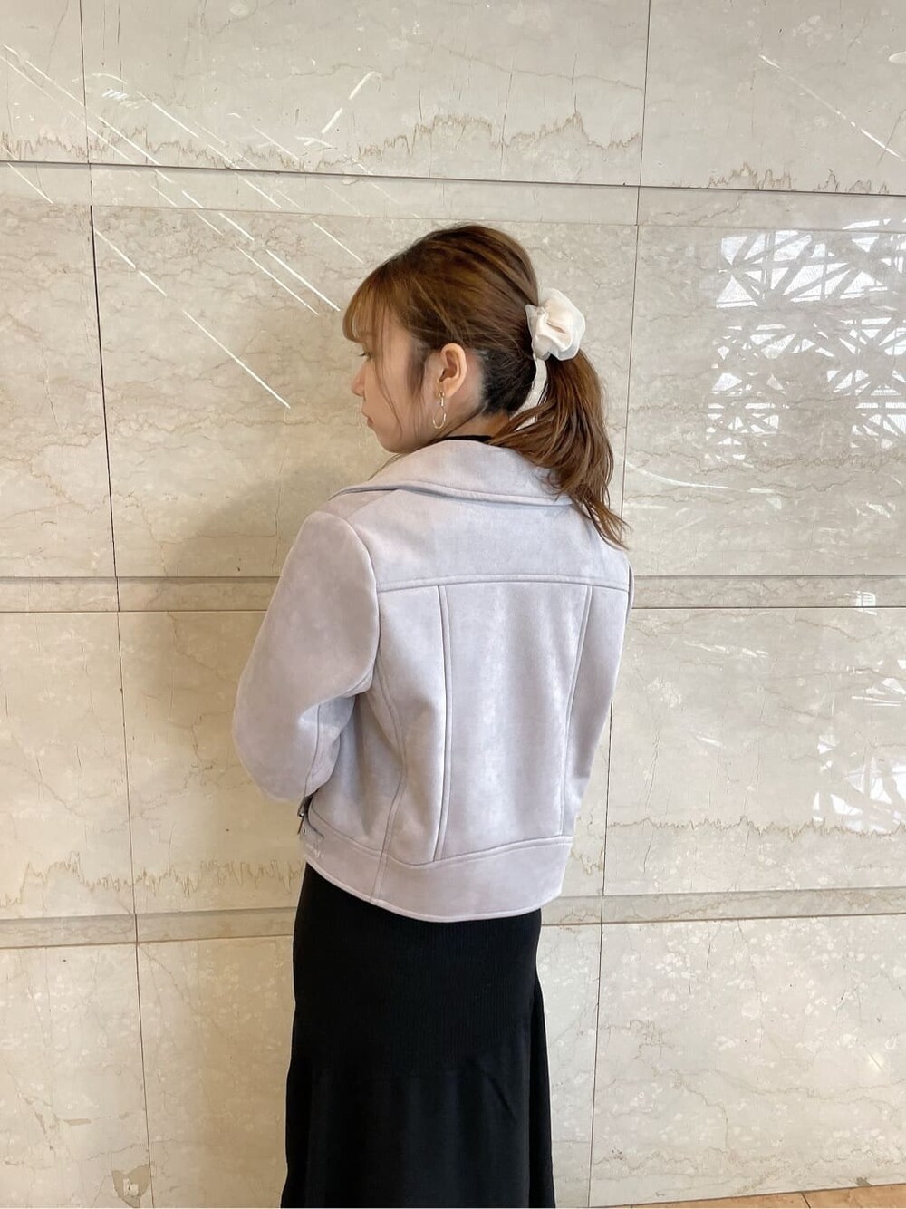 パープル系のライダースジャケット、ベージュ系のブーツ、ブラック系のワンピースを着用したレディースの秋コーディネートの6枚目の写真