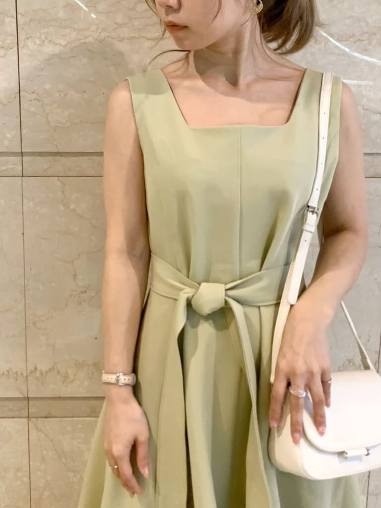 グリーン系のワンピース、ブラウン系のサンダル、ホワイト系のシャツ/ブラウスを着用したレディースの春コーディネートの4枚目の写真