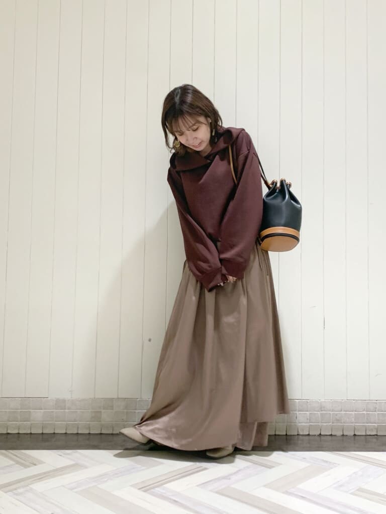 ベージュ系のワンピース、ブラック系のバックパック/リュック、ベージュ系のブーツを着用したレディースの秋コーディネートの3枚目の写真