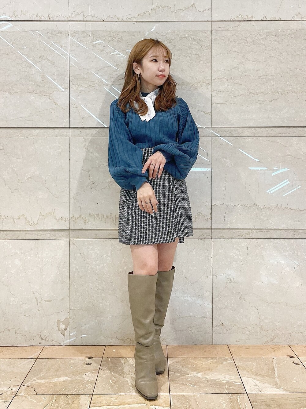 ブルー系のニット/セーター、ブラウン系のブーツ、ブルー系のスカートを着用したレディースの冬コーディネートの2枚目の写真