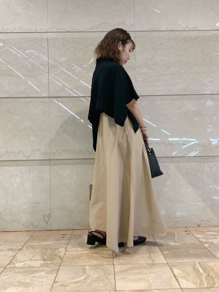 ベージュ系のワンピース、ブラック系のパンプス、ブラック系のハンドバッグを着用したレディースの夏コーディネートの3枚目の写真