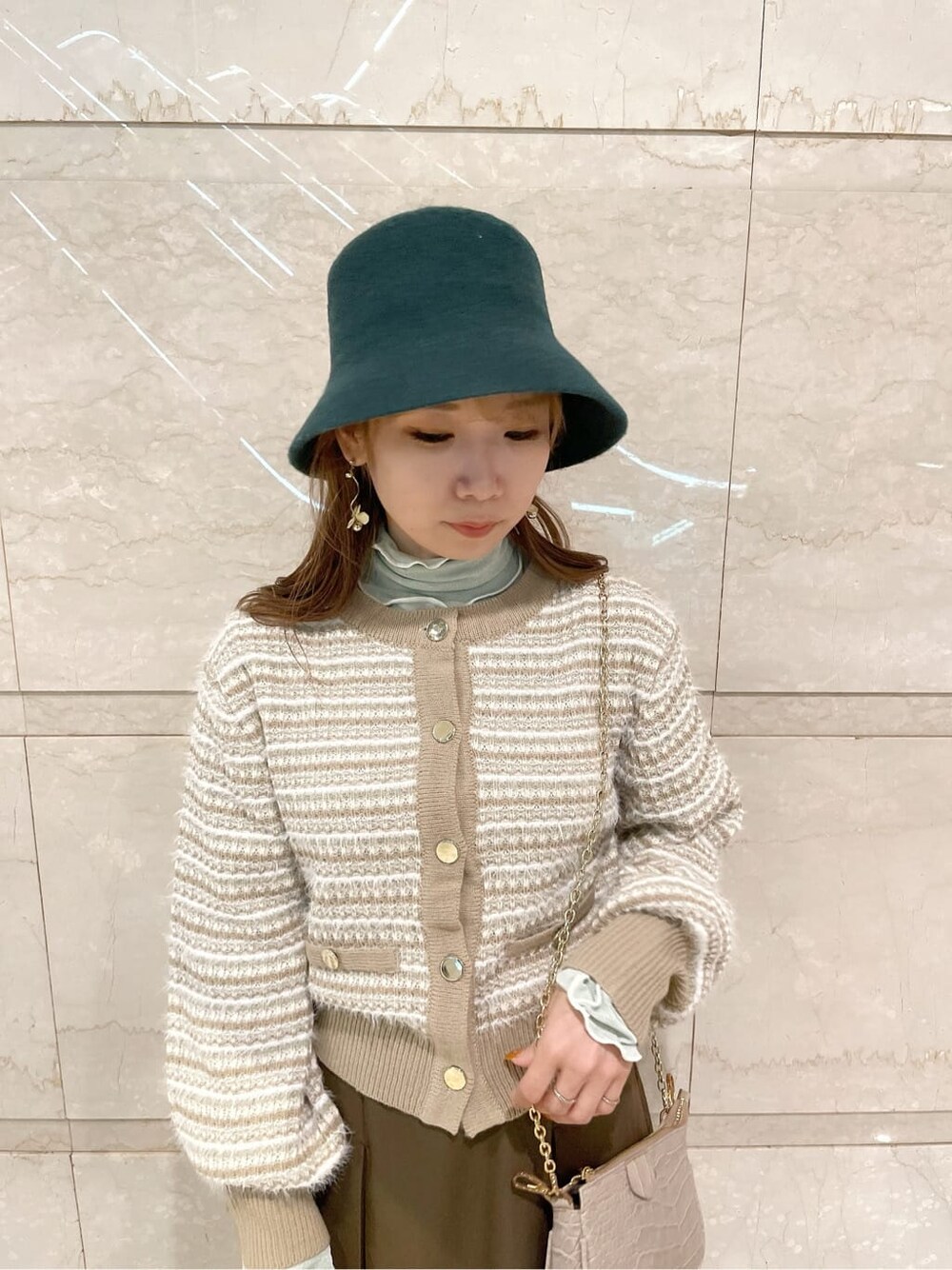 ブラウン系のスカート、ベージュ系のブーツ、ベージュ系のカーディガン/ボレロを着用したレディースの秋コーディネートの5枚目の写真