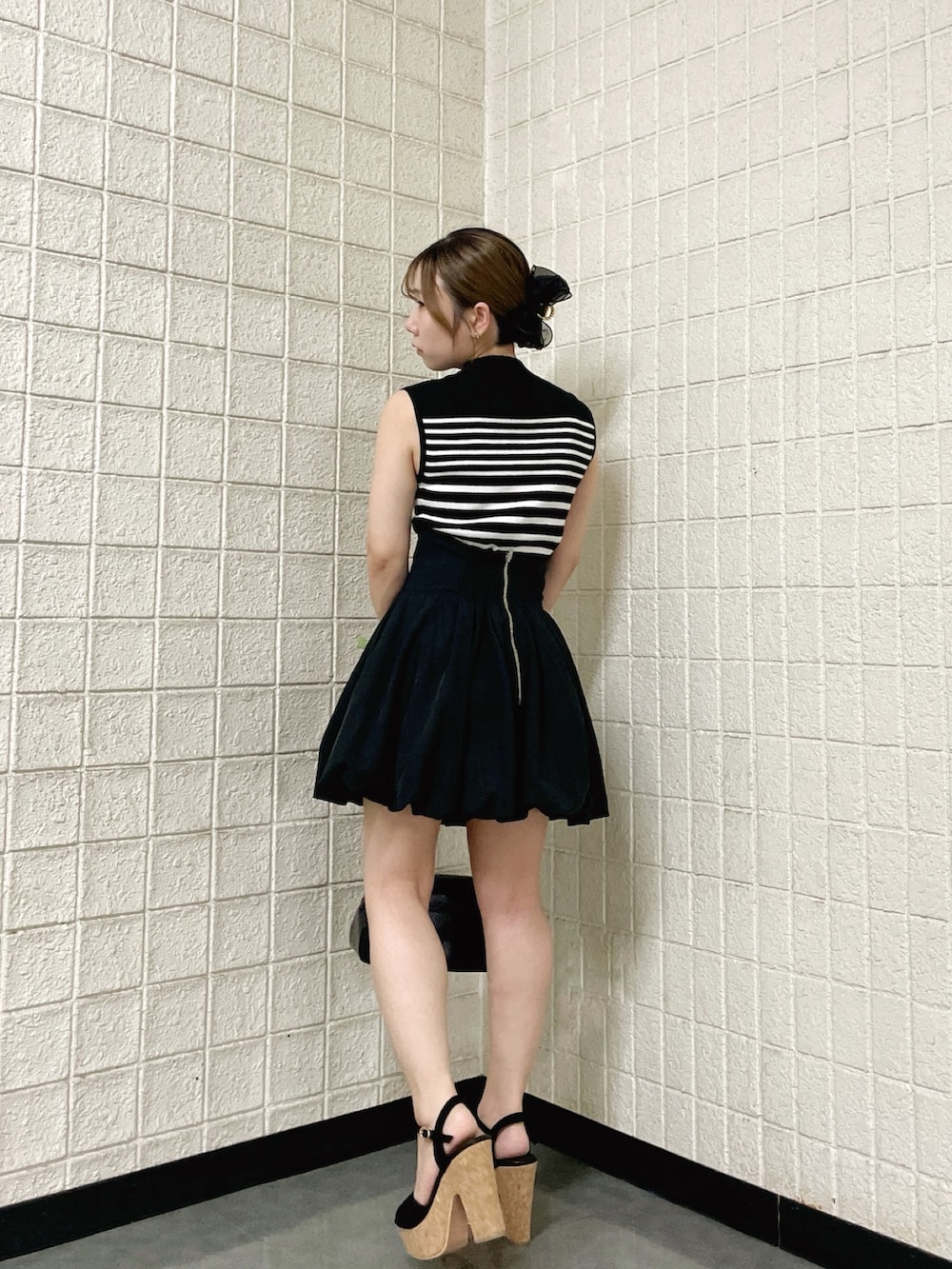 その他のニット/セーター、ブラック系のスカート、ブラック系のハンドバッグを着用したレディースの春コーディネートの5枚目の写真