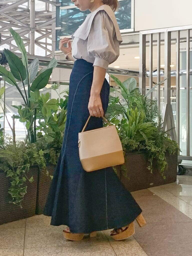 グレー系のシャツ/ブラウス、ベージュ系のハンドバッグ、ブラウン系のサンダルを着用したレディースの春コーディネートの2枚目の写真