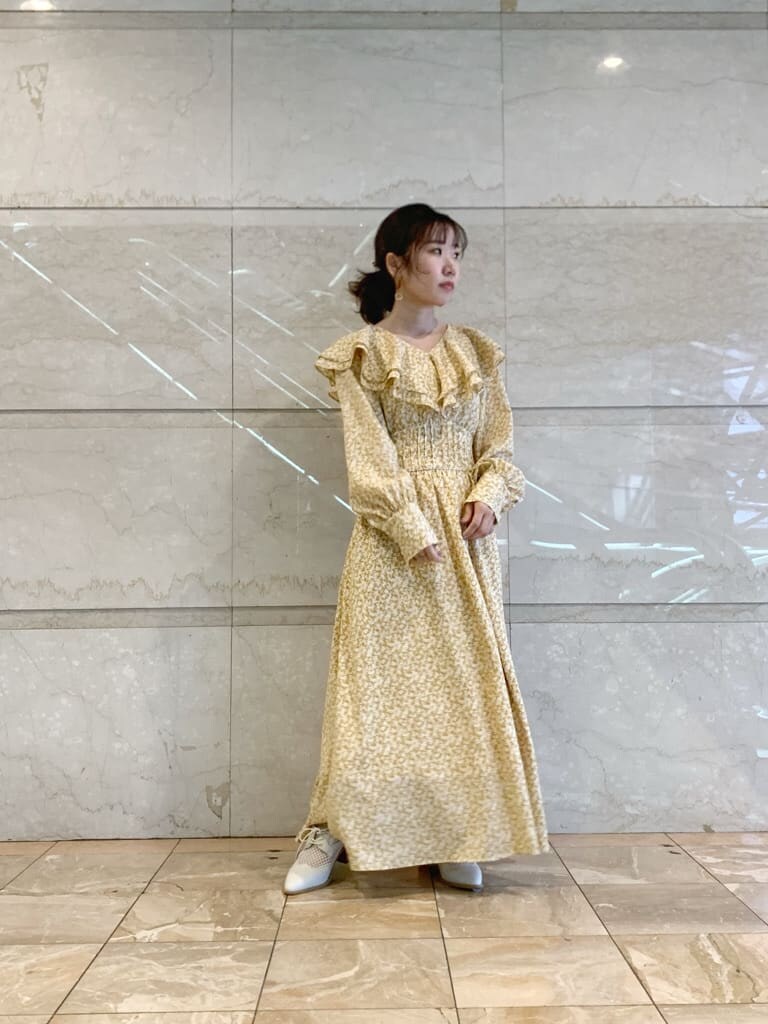 イエロー系のワンピース、ホワイト系のローファーを着用したレディースの冬コーディネートの3枚目の写真