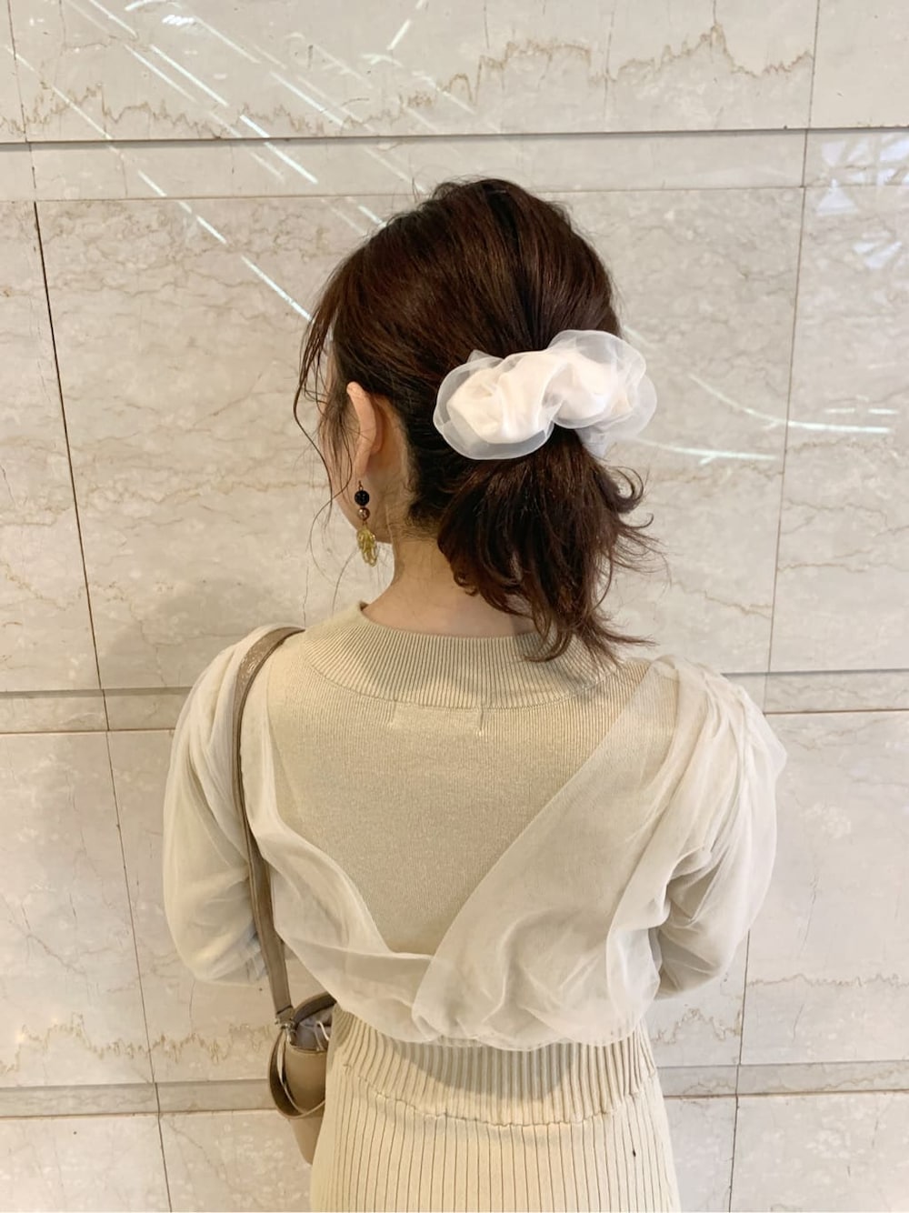 ブラック系のブーツ、ブラウン系のチェスターコート、ベージュ系のワンピースを着用したレディースの冬コーディネートの4枚目の写真