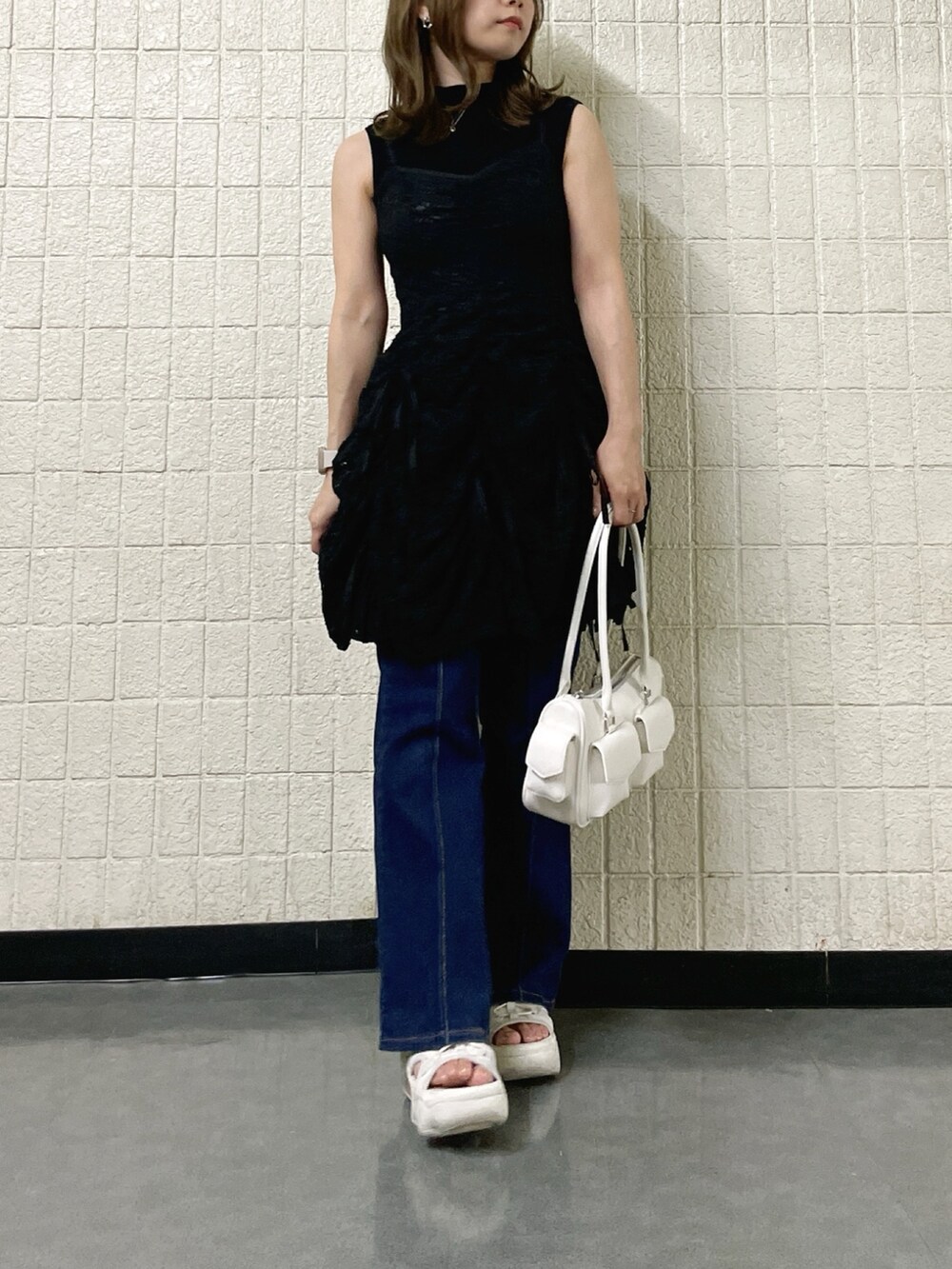 ブラック系のワンピース、ブラック系のニット/セーター、ホワイト系のボストンバッグを着用したレディースの春コーディネートの3枚目の写真