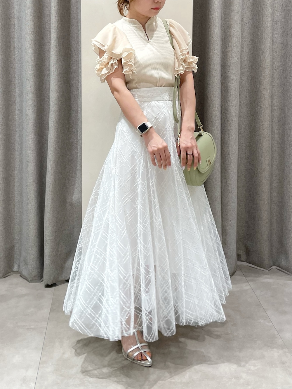 ベージュ系のTシャツ/カットソー、ホワイト系のスカート、シルバー系のパンプスを着用したレディースの夏コーディネートの4枚目の写真