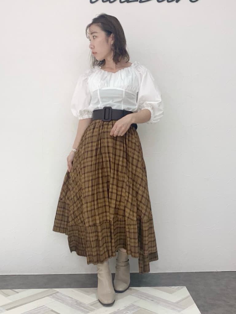 ホワイト系のシャツ/ブラウス、ブラウン系のスカート、ベージュ系のブーツを着用したレディースの夏コーディネートの2枚目の写真