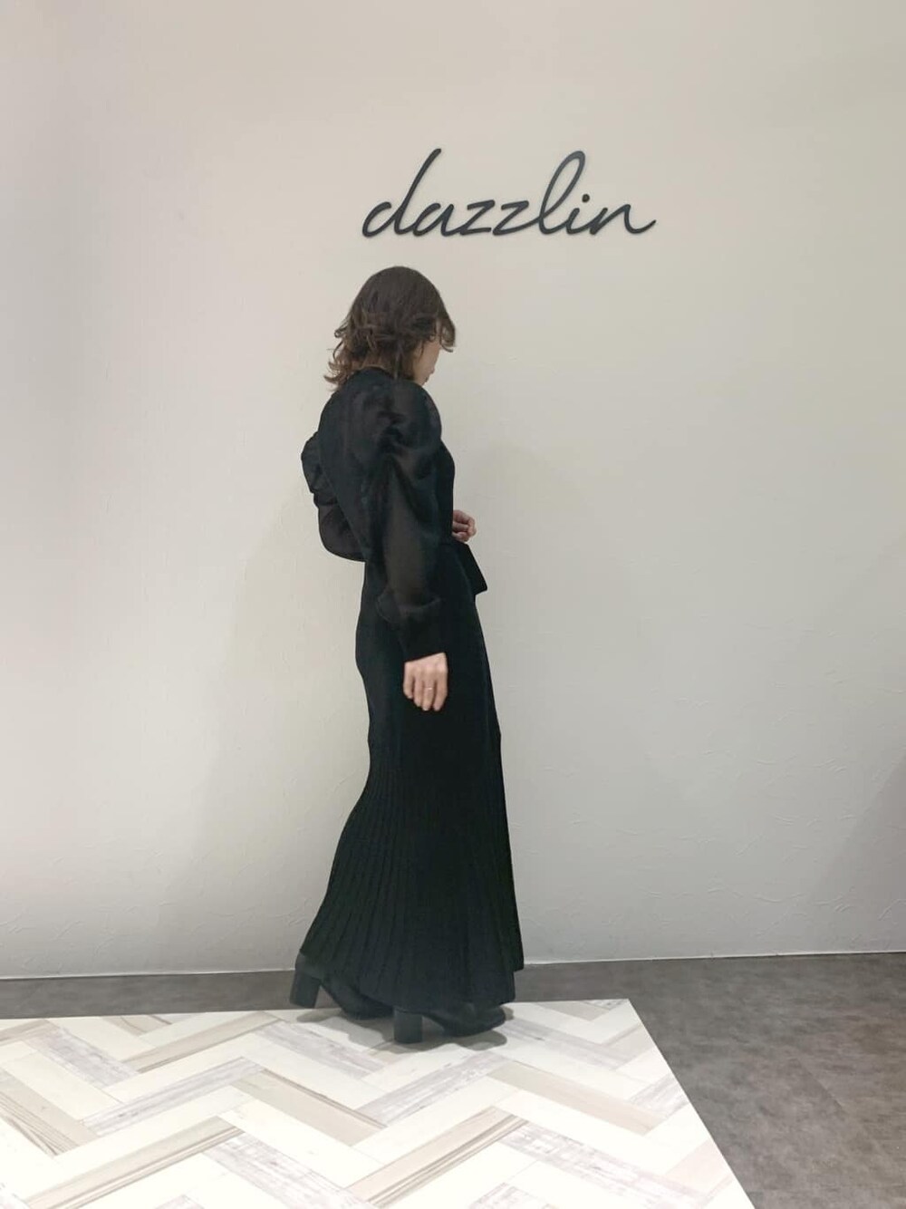 ブラック系のブルゾン、ブラック系のワンピース、ブラック系のブーツを着用したレディースの秋コーディネートの5枚目の写真