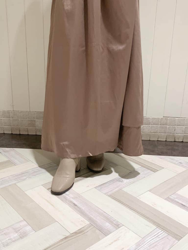 ベージュ系のワンピース、ブラック系のバックパック/リュック、ベージュ系のブーツを着用したレディースの秋コーディネートの8枚目の写真