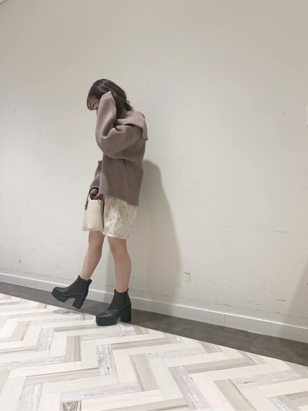 ブラウン系のブーツ、ベージュ系のニット/セーター、ベージュ系のスカートを着用したレディースの秋コーディネートの3枚目の写真