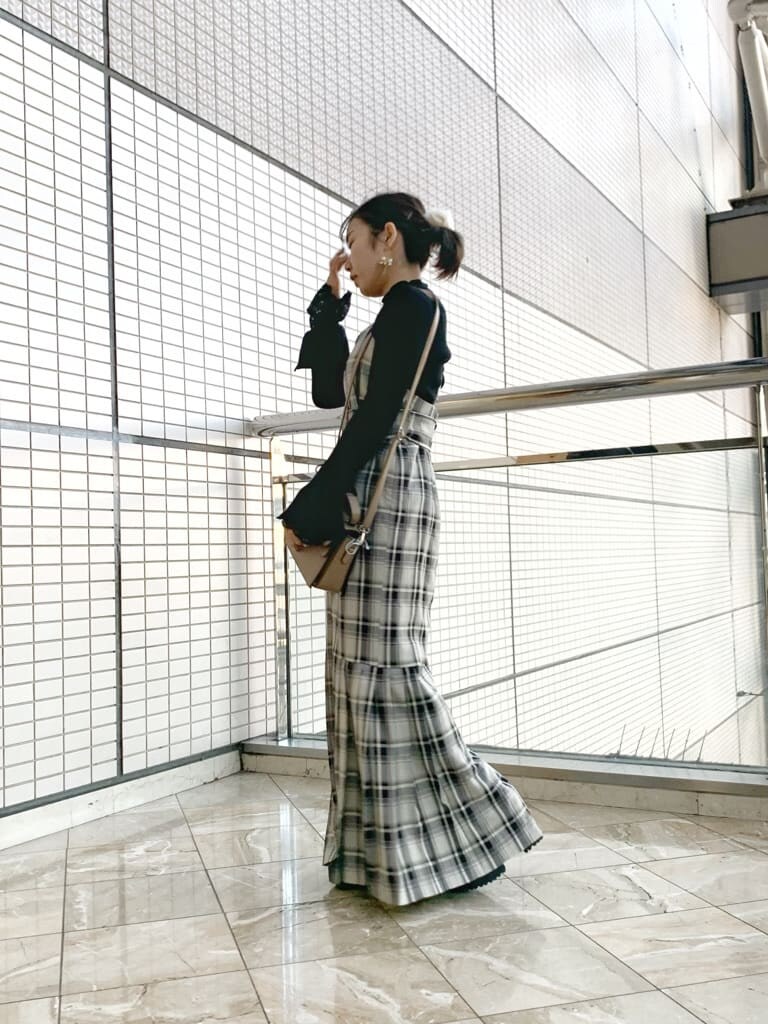 ブラック系のブーツ、グレー系のジャンパースカート、ブラック系のニット/セーターを着用したレディースの冬コーディネートの4枚目の写真