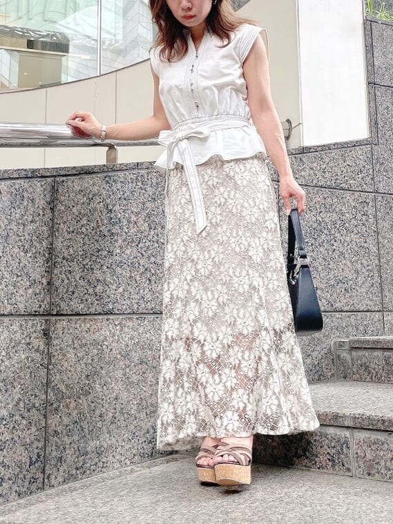 ベージュ系のスカート、ブラウン系のサンダル、ホワイト系のシャツ/ブラウスを着用したレディースの夏コーディネートの5枚目の写真