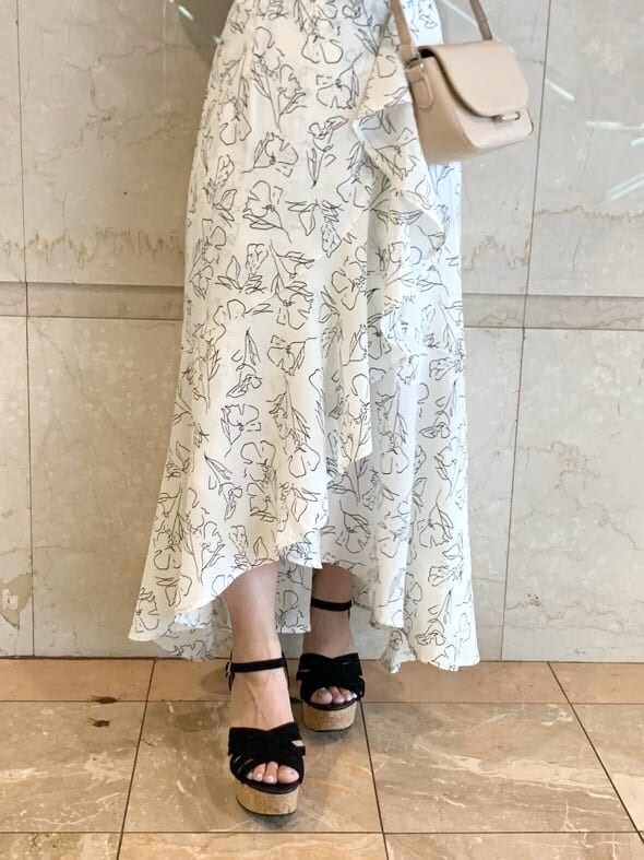 ブラック系のサンダル、ベージュ系のショルダーバッグ、ホワイト系のスカートを着用したレディースの春コーディネートの8枚目の写真