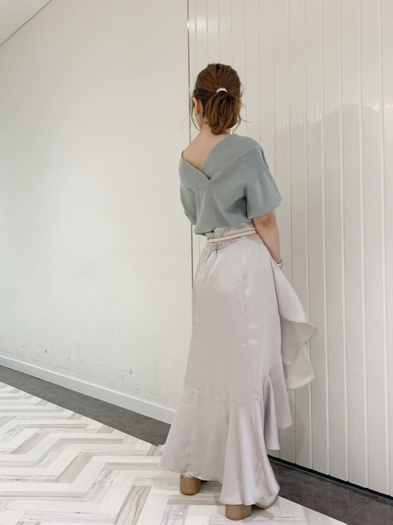 グリーン系のニット/セーター、グレー系のスカート、ホワイト系のローファーを着用したレディースの春コーディネートの4枚目の写真