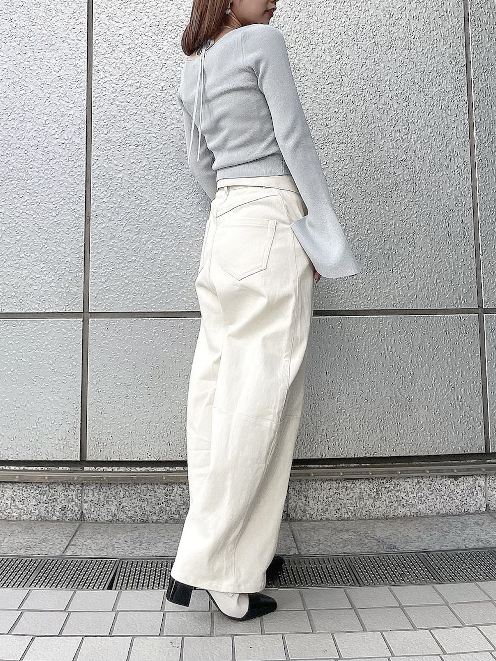 グレー系のニット/セーター、ホワイト系のデニムパンツ、その他のパンプスを着用したレディースの冬コーディネートの3枚目の写真