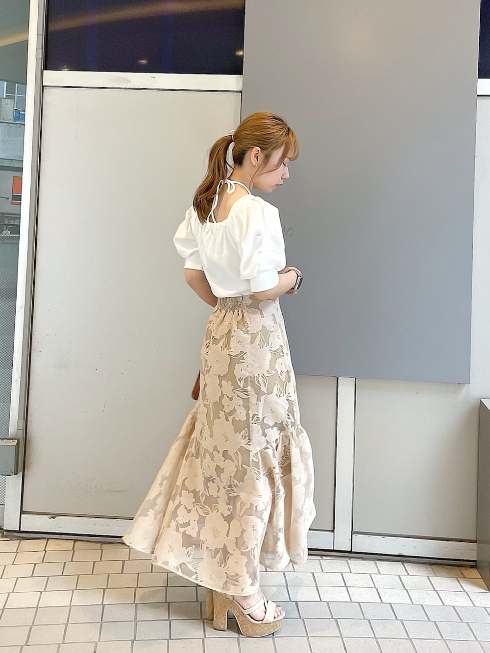 ホワイト系のサンダル、イエロー系のハンドバッグ、ホワイト系のTシャツ/カットソーを着用したレディースの夏コーディネートの3枚目の写真