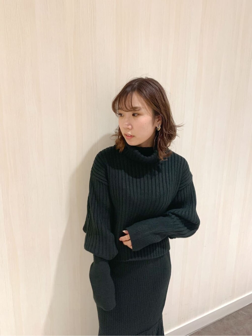 ブラック系のスカート、ブラック系のブーツ、ブラック系のニット/セーターを着用したレディースの秋コーディネートの7枚目の写真