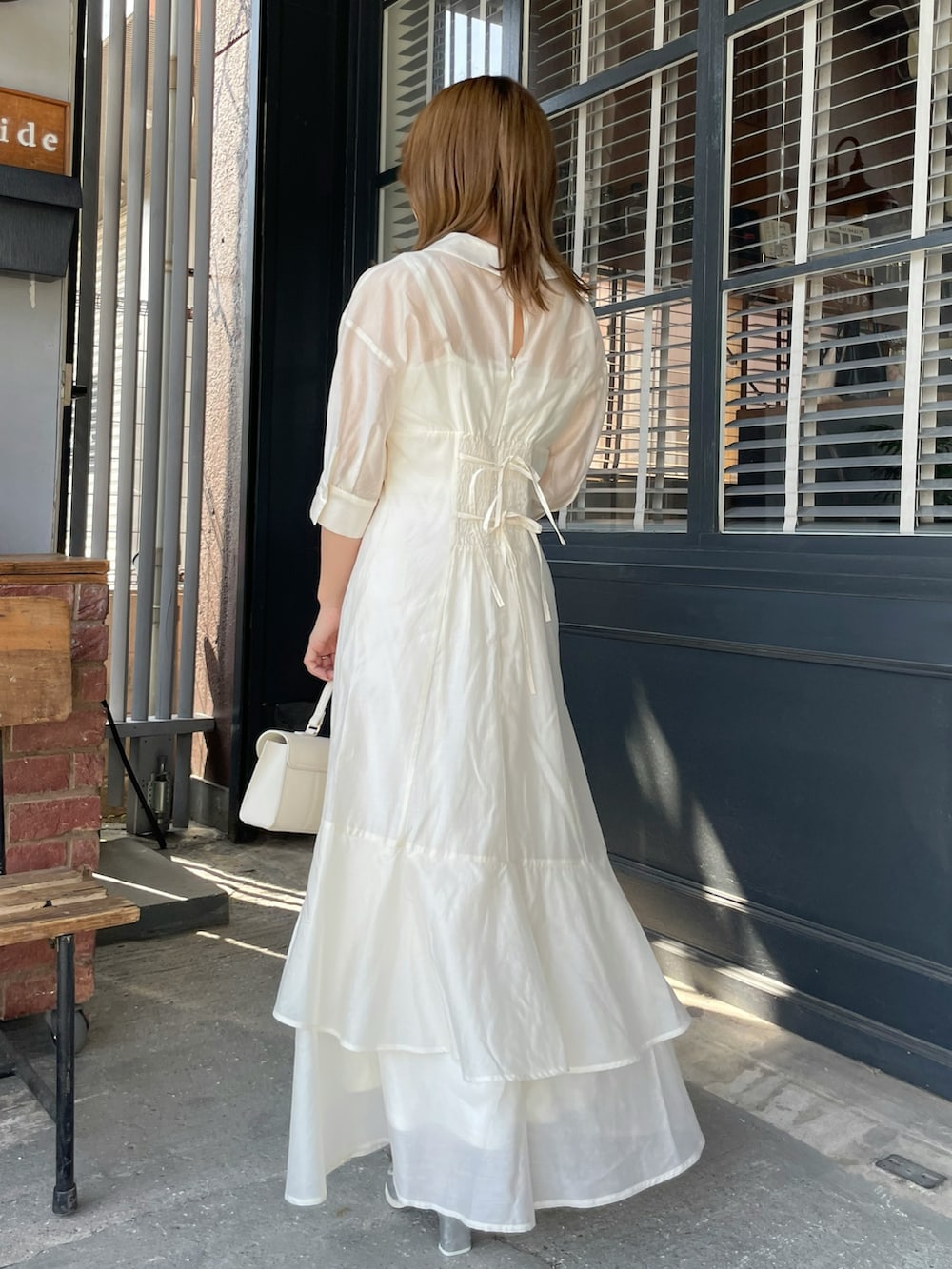 ホワイト系のワンピース、シルバー系のローファーを着用したレディースの夏コーディネートの3枚目の写真