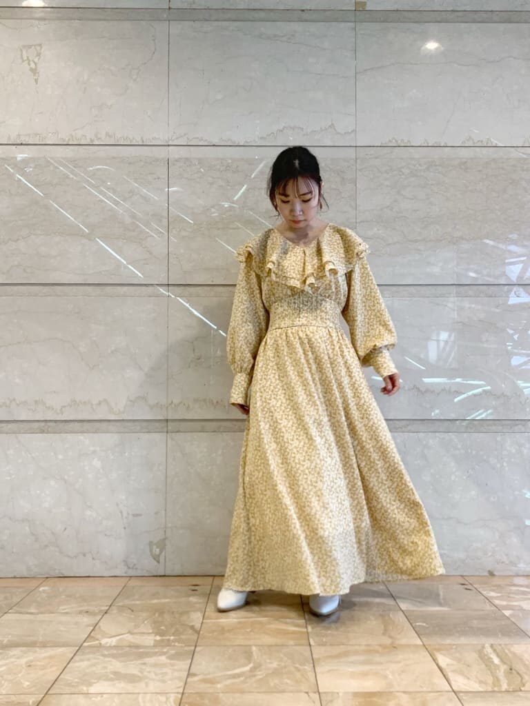 イエロー系のワンピース、ホワイト系のローファーを着用したレディースの冬コーディネートの2枚目の写真