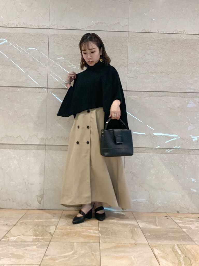 ベージュ系のワンピース、ブラック系のパンプス、ブラック系のハンドバッグを着用したレディースの夏コーディネートの2枚目の写真