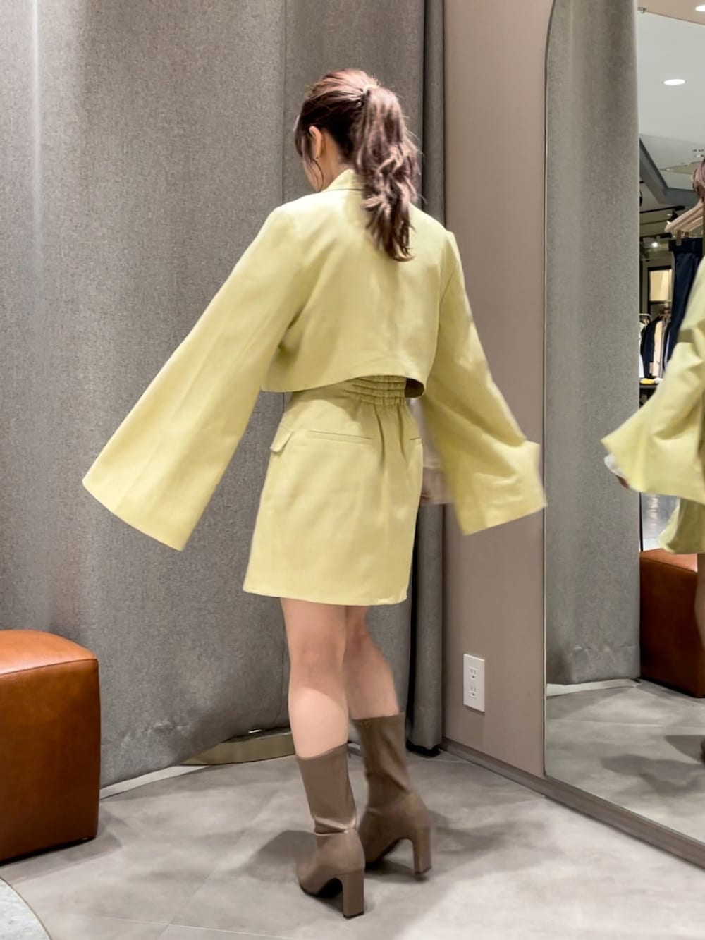 イエロー系のテーラードジャケット、イエロー系のスカート、ベージュ系のシャツ/ブラウスを着用したレディースの秋コーディネートの2枚目の写真
