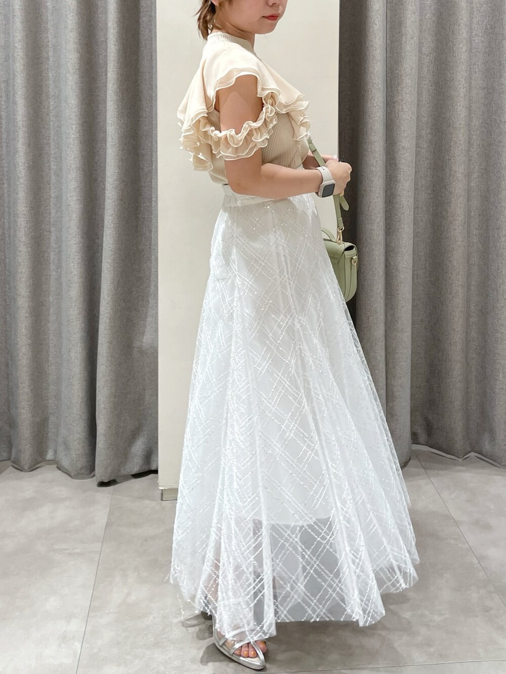 ベージュ系のTシャツ/カットソー、ホワイト系のスカート、シルバー系のパンプスを着用したレディースの夏コーディネートの2枚目の写真