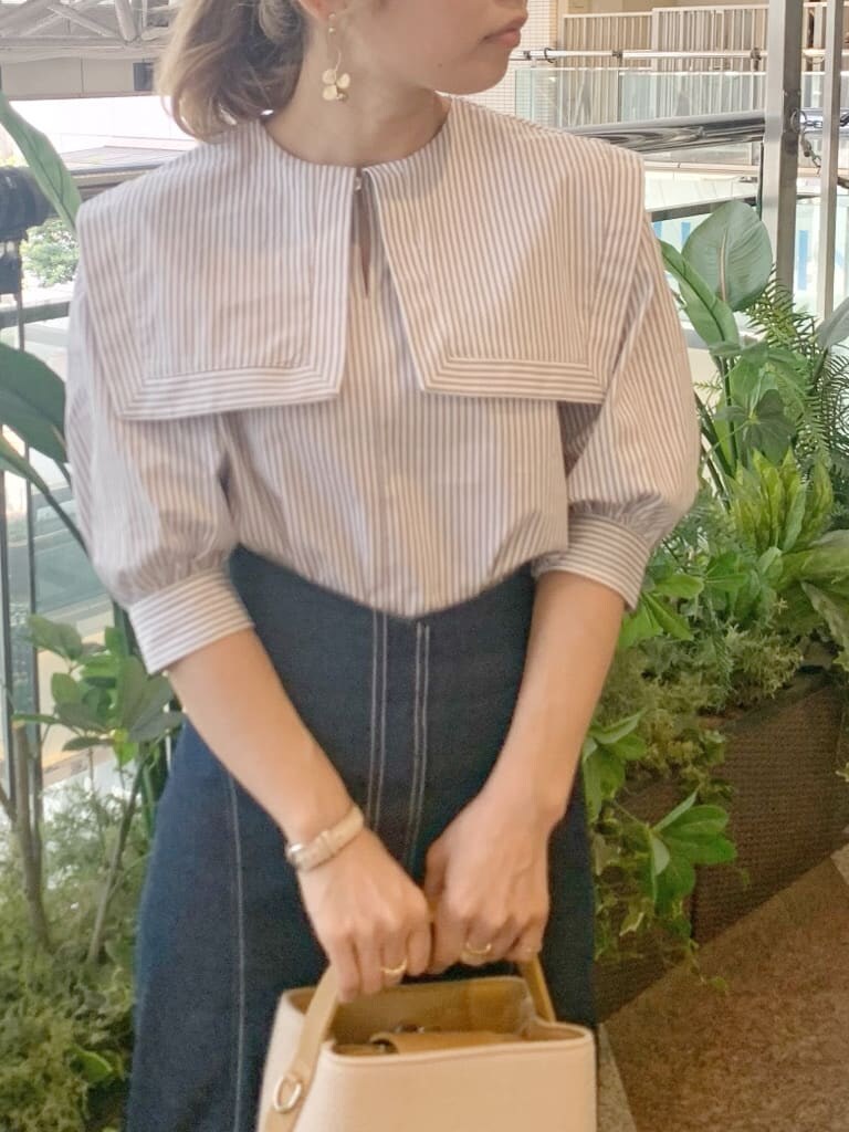 グレー系のシャツ/ブラウス、ベージュ系のハンドバッグ、ブラウン系のサンダルを着用したレディースの春コーディネートの4枚目の写真