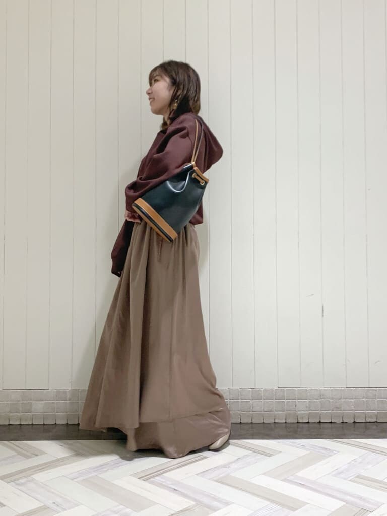 ベージュ系のワンピース、ブラック系のバックパック/リュック、ベージュ系のブーツを着用したレディースの秋コーディネートの6枚目の写真