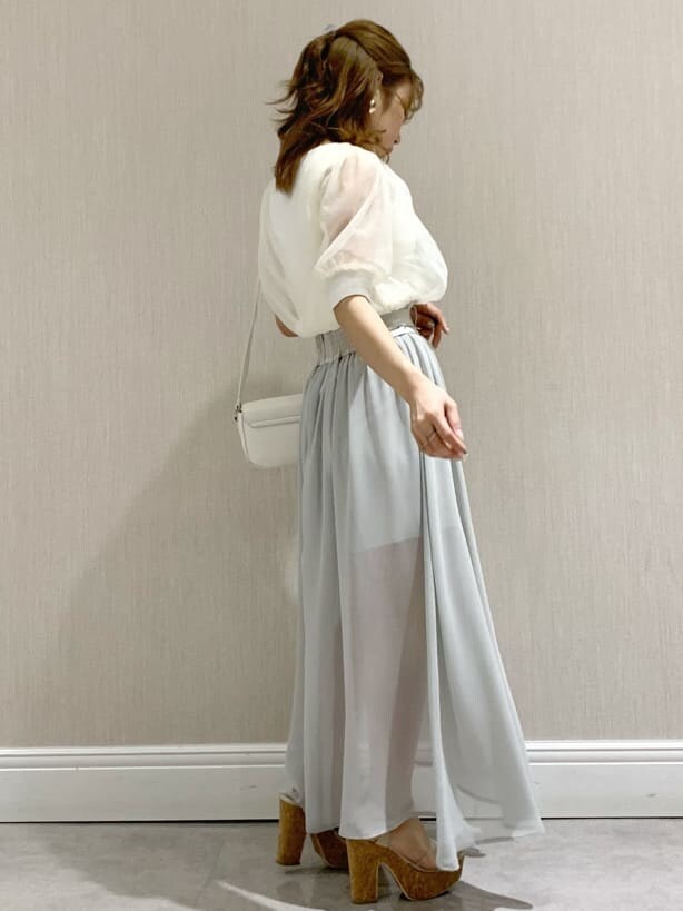 ホワイト系のニット/セーター、ホワイト系のショルダーバッグ、グレー系のスカートを着用したレディースの春コーディネートの4枚目の写真