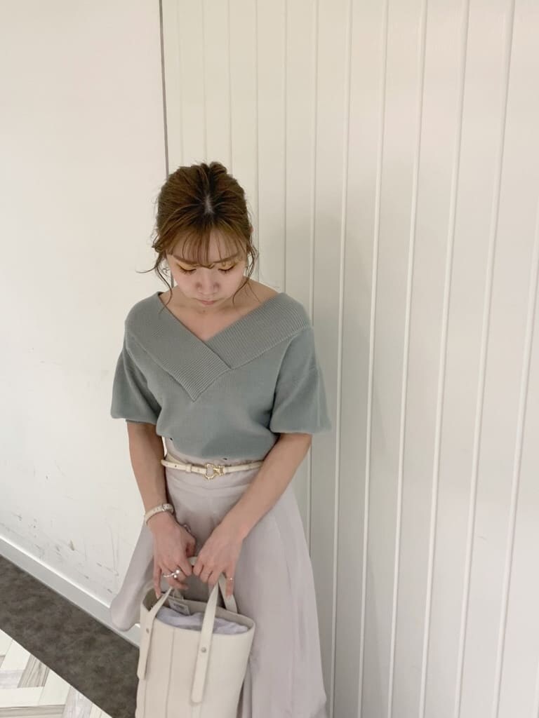 グリーン系のニット/セーター、グレー系のスカート、ホワイト系のローファーを着用したレディースの春コーディネートの7枚目の写真