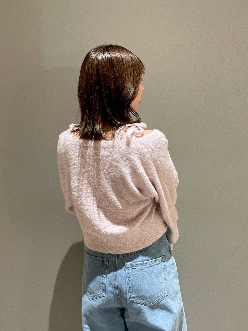 ピンク系のニット/セーター、ピンク系のカーディガン/ボレロ、ブルー系のデニムパンツを着用したレディースの秋コーディネートの5枚目の写真