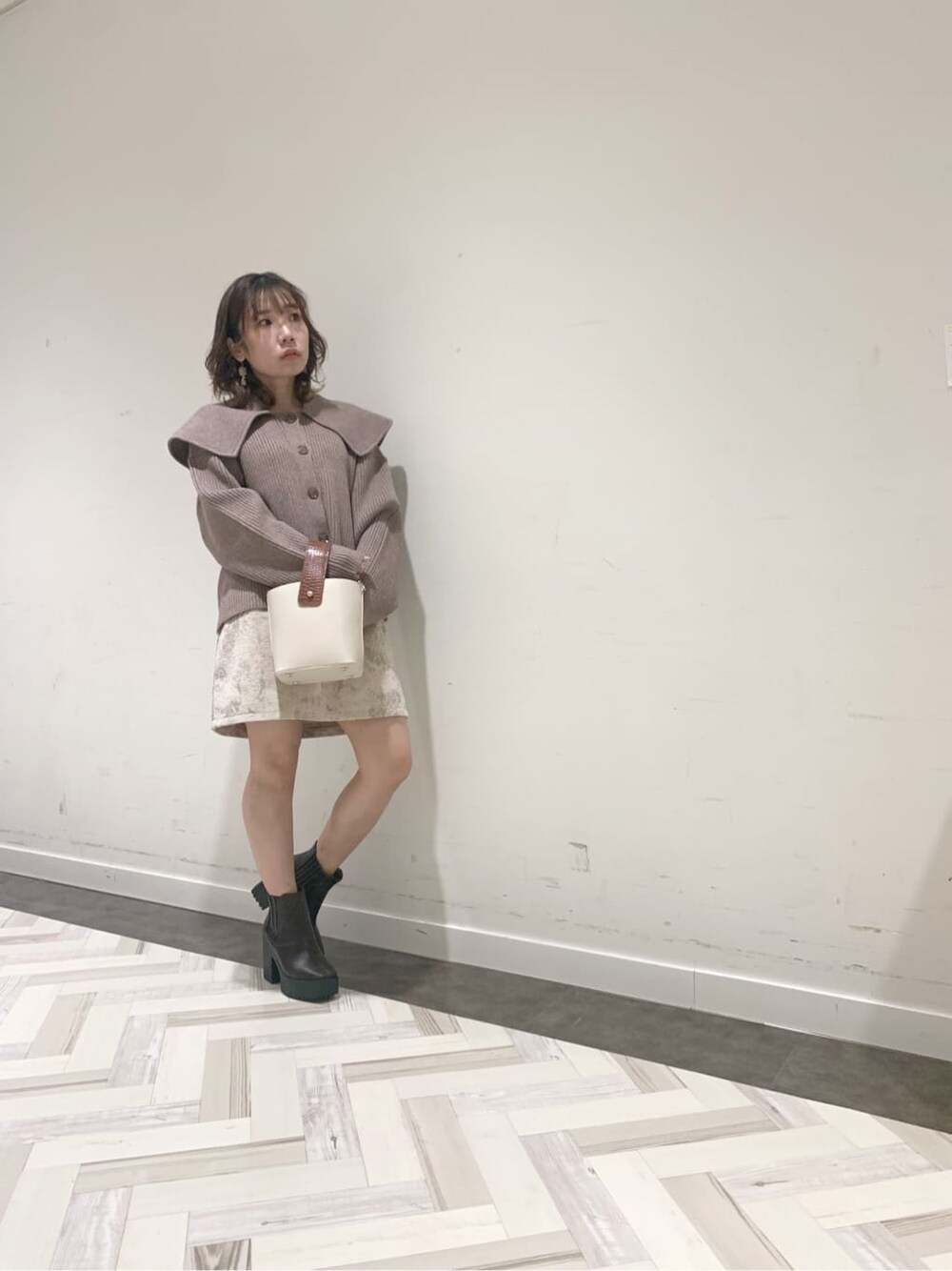 ブラウン系のブーツ、ベージュ系のニット/セーター、ベージュ系のスカートを着用したレディースの秋コーディネートの2枚目の写真