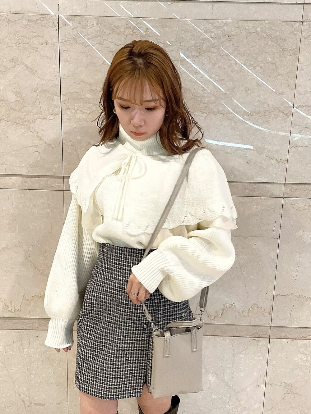 ホワイト系のニット/セーター、ブルー系のスカート、ブラック系のブーツを着用したレディースの秋コーディネートの6枚目の写真