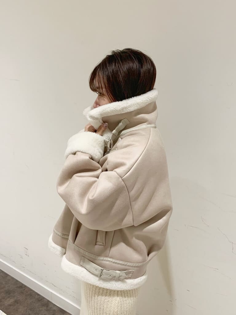 ホワイト系のワンピース、ホワイト系のブルゾン、ブラック系のブーツを着用したレディースの秋コーディネートの10枚目の写真