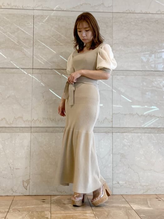 ベージュ系のワンピースを着用したレディースの春コーディネートの2枚目の写真