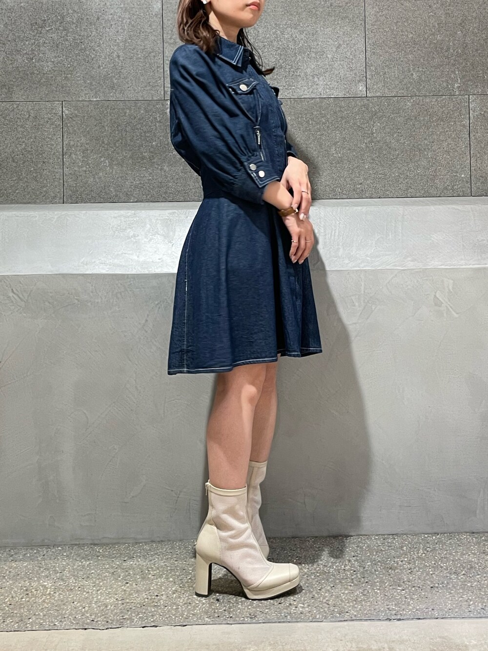 ブルー系のシャツワンピース、ホワイト系のブーツを着用したレディースの冬コーディネートの3枚目の写真