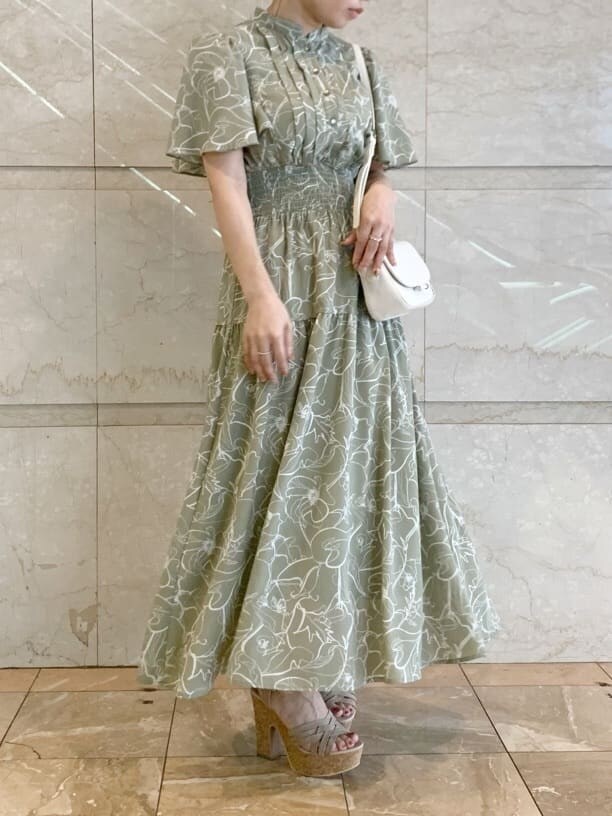 グリーン系のワンピース、ベージュ系のサンダル、ホワイト系のショルダーバッグを着用したレディースの春コーディネートの4枚目の写真