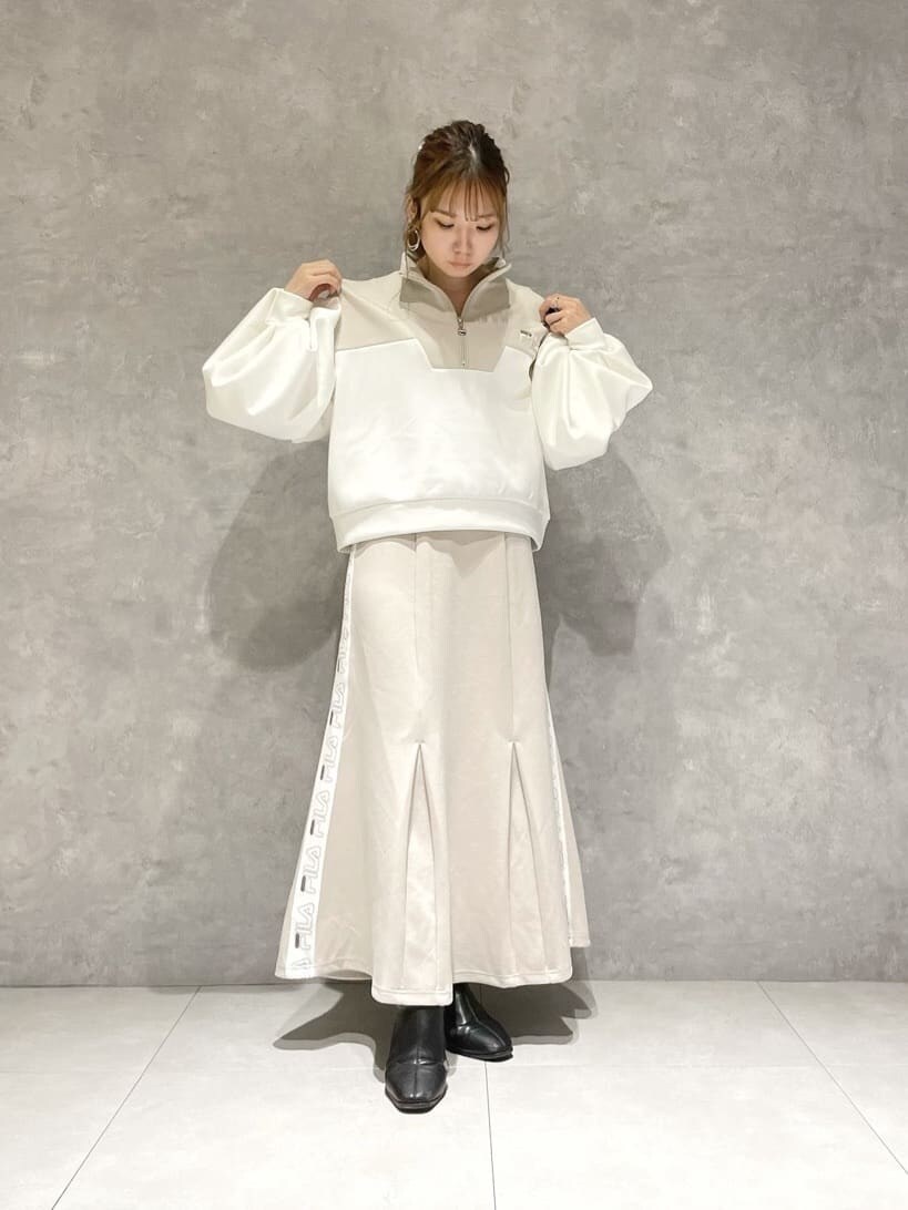 ベージュ系のスカート、ブラック系のブーツ、ベージュ系のTシャツ/カットソーを着用したレディースの秋コーディネートの2枚目の写真