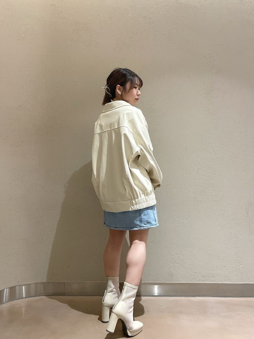 ホワイト系のブルゾン、ブルー系のワンピース、ホワイト系のブーツを着用したレディースの冬コーディネートの2枚目の写真