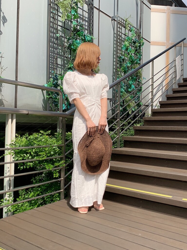 ホワイト系のワンピース、その他のサンダル、ブラウン系のハットを着用したレディースの春コーディネートの2枚目の写真