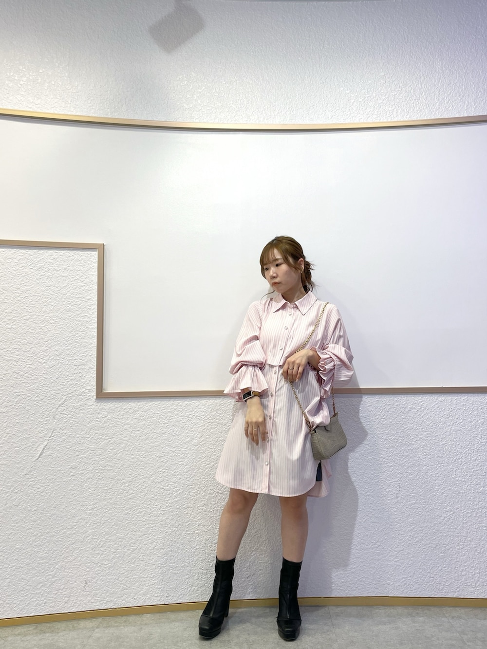 ピンク系のワンピース、ブラック系のブーツ、グレー系のスカートを着用したレディースの春コーディネートの2枚目の写真